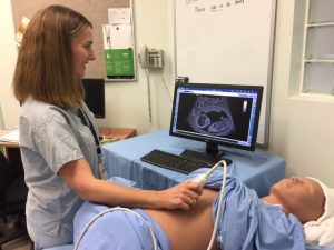 Sonographer practices an ultrasound on an obstetrics simulator.