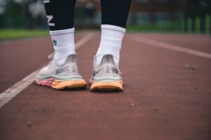 A photo of a person wearing running shoes standing on a track