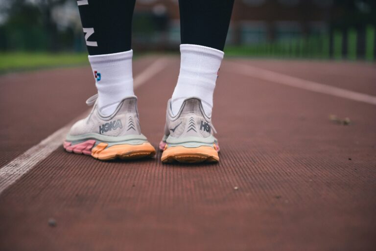 A photo of a person wearing running shoes standing on a track